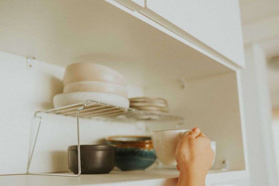 Neatly organized kitchen shelves with baskets and labeled containers