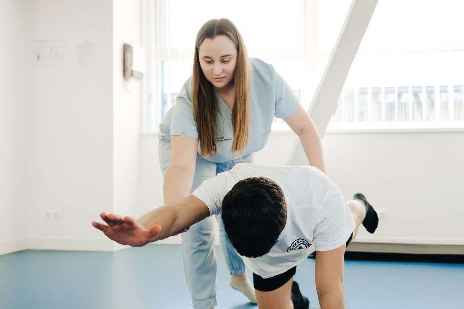 A physical therapist guiding a patient through rehabilitation exercises in a clinic