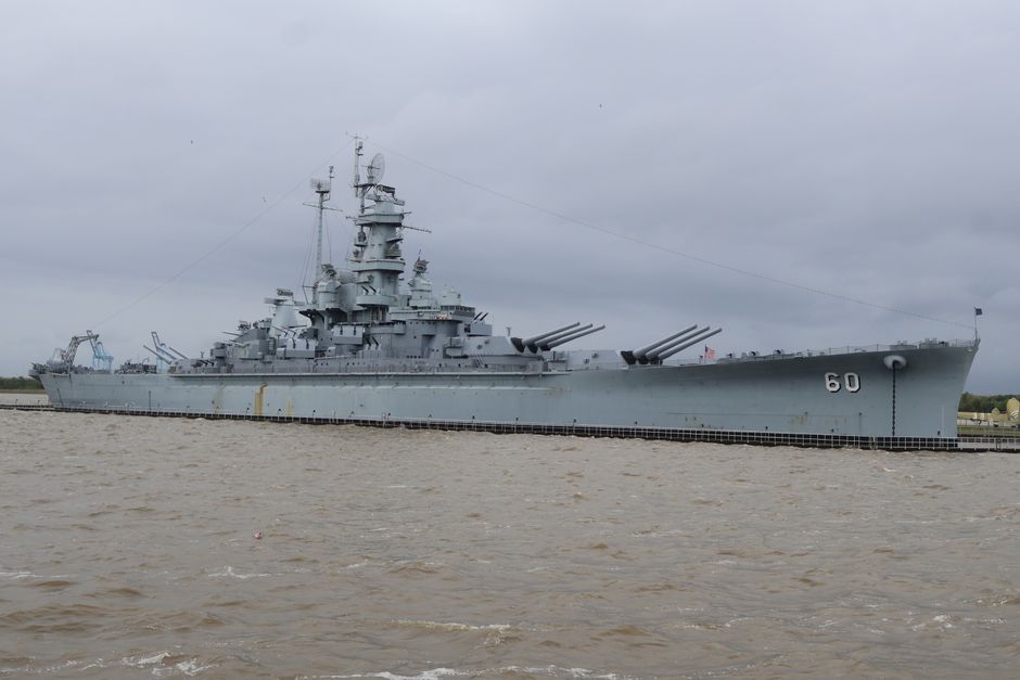 The gray hull of the USS Alabama battleship along the Mobile Bay waterfront