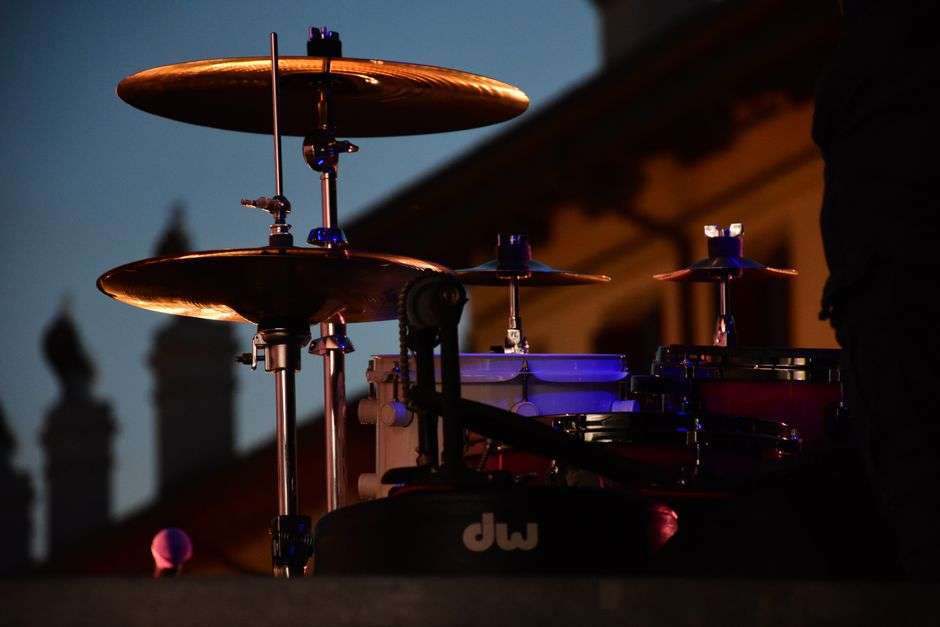 A drum kit lit by stage lights at a concert venue