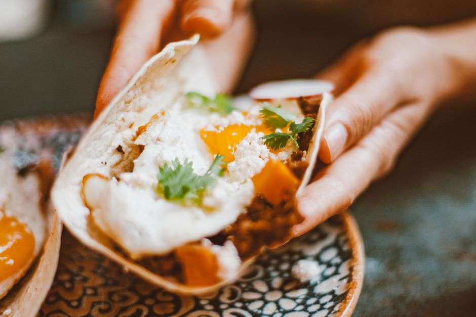 A plate of breakfast tacos with salsa on a restaurant table