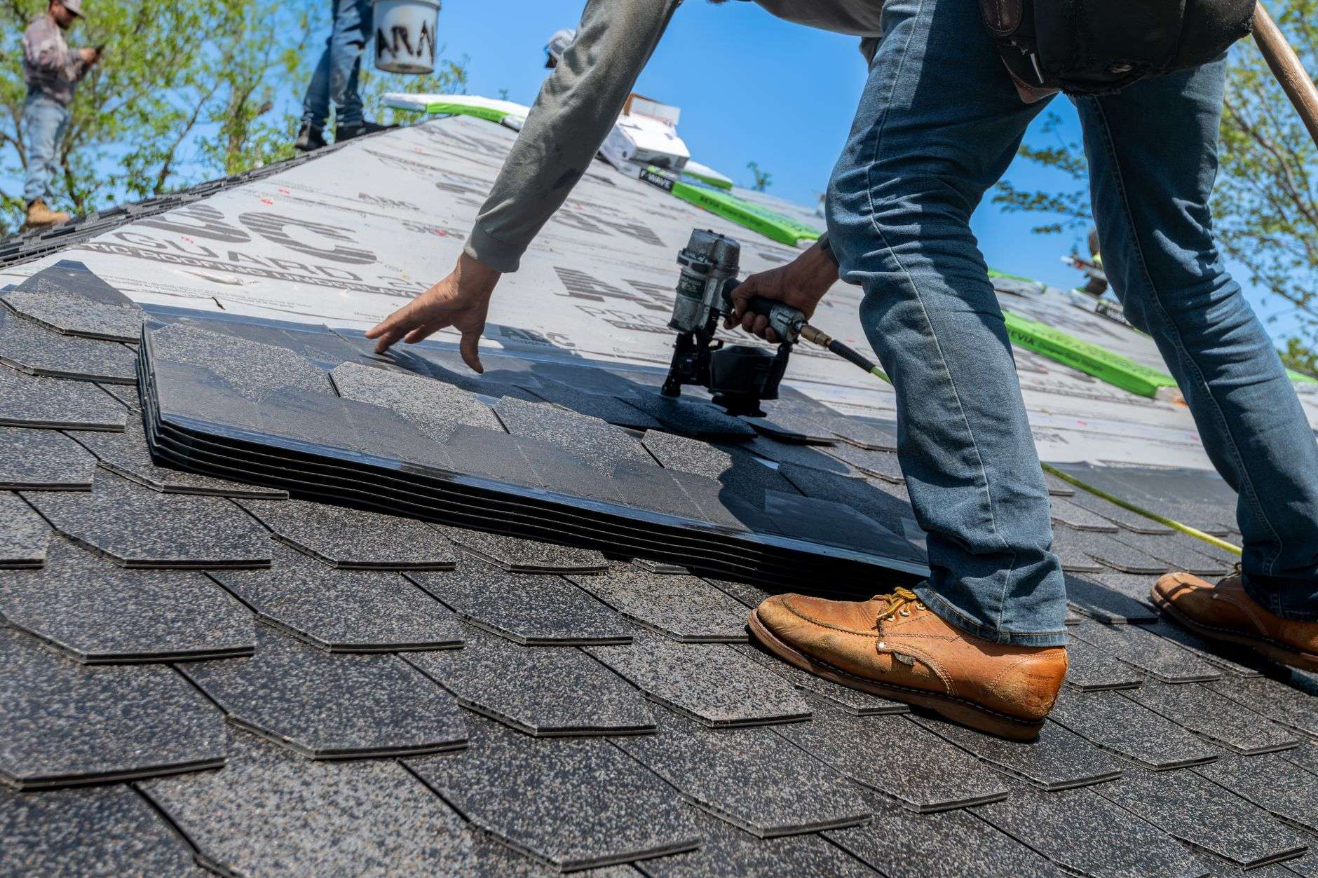 Roofing shingles being installed on a building, illustrating a school auditorium roof replacement project