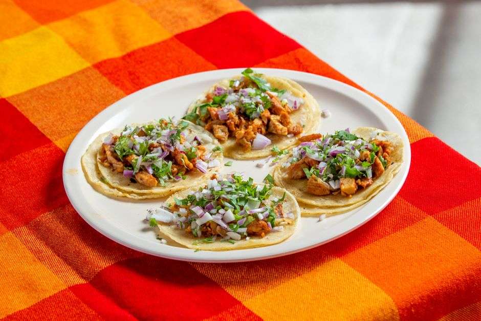 A plate of street tacos with fresh toppings at a restaurant
