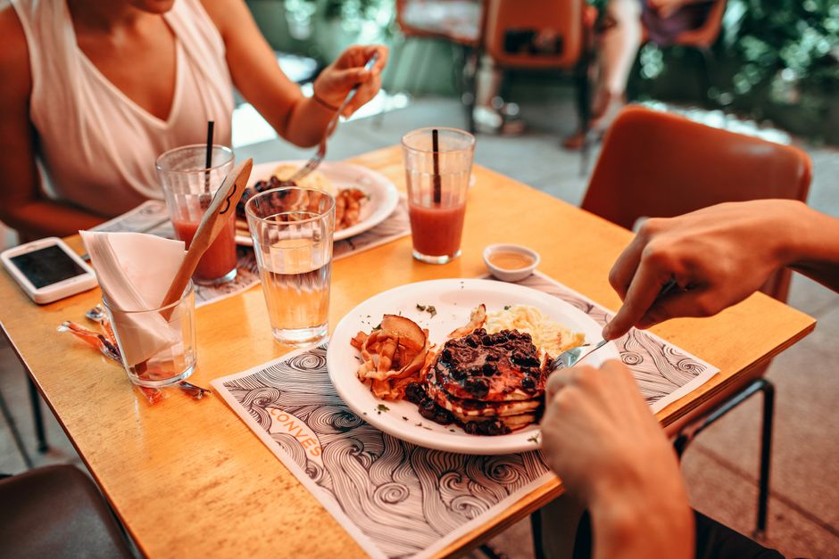 A brunch table with breakfast plates, french toast, and coffee at a restaurant