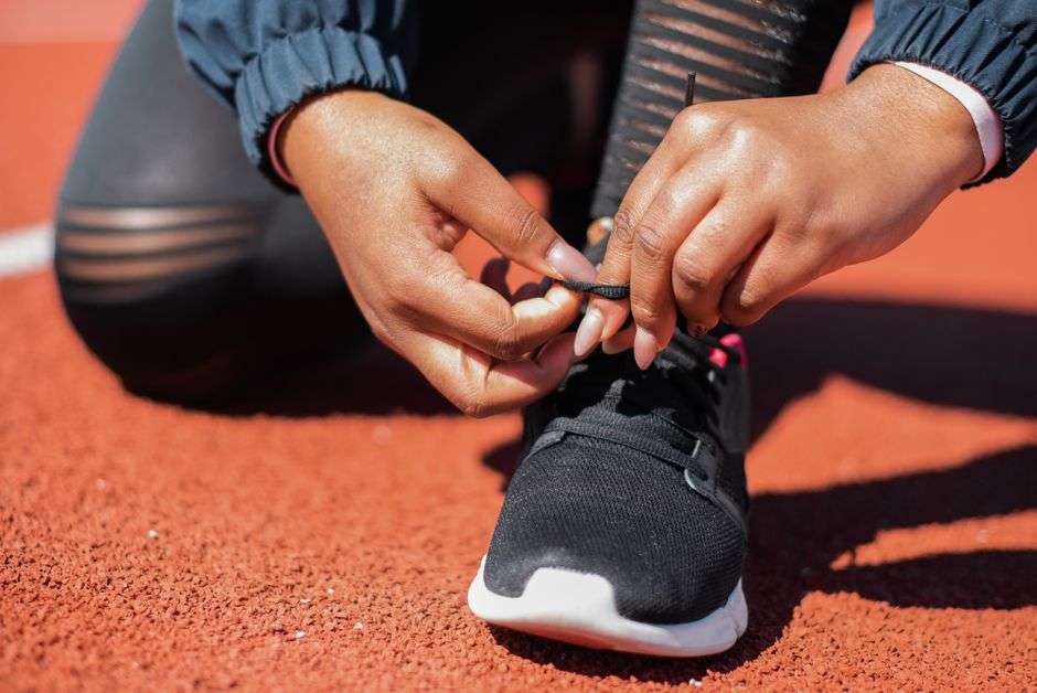 A pair of running shoes being laced before a training run on the Gulf Coast