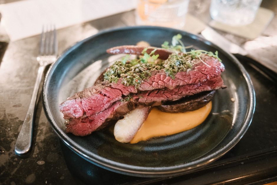 A plated steak dinner in an upscale restaurant dining room