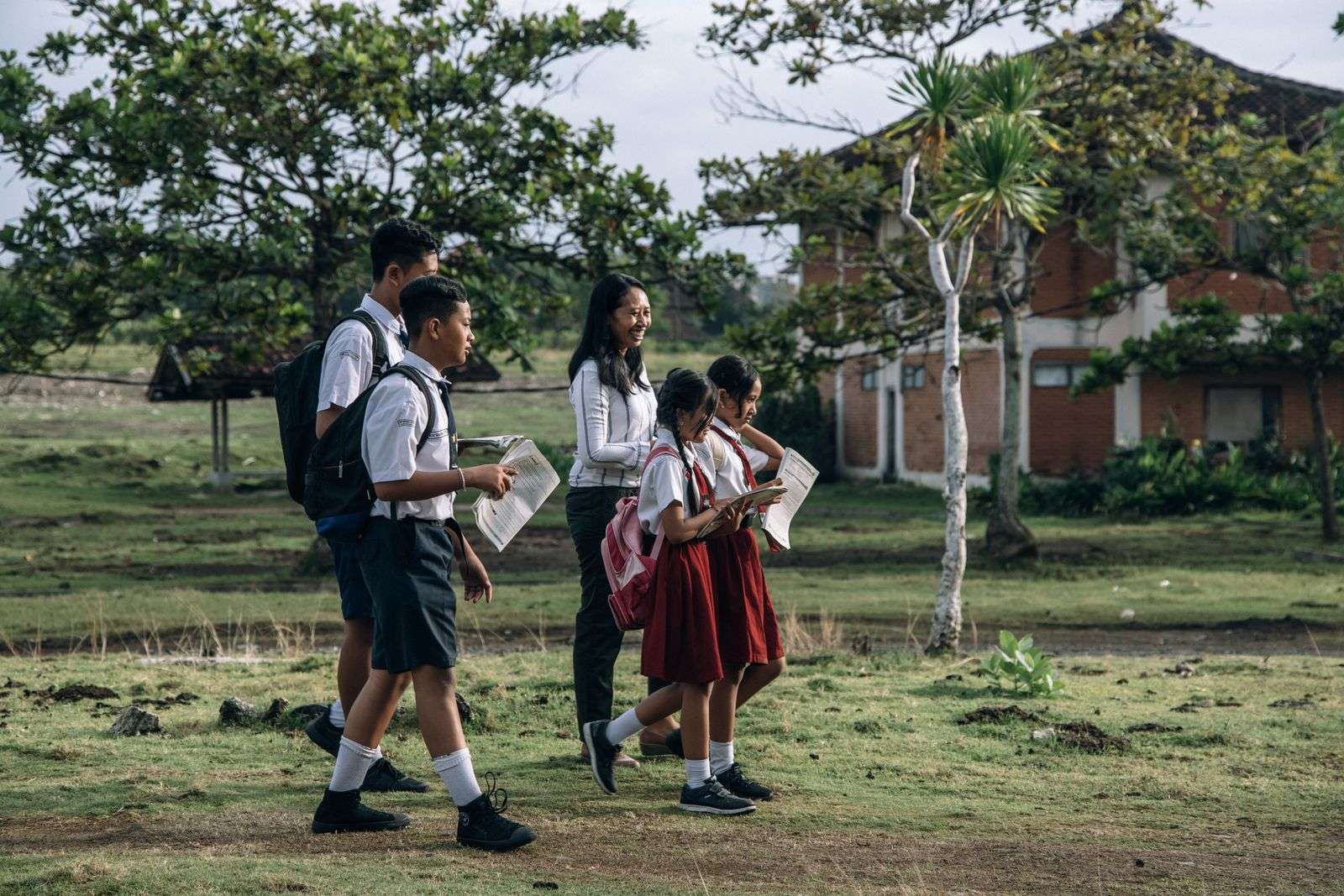 Students with backpacks walking along a sidewalk after school