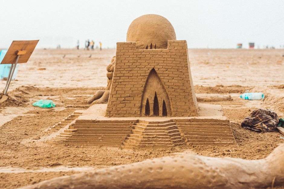 An elaborate sand castle sculpture built on a sandy beach