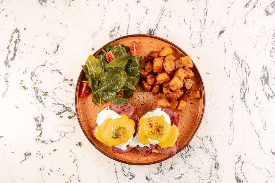 Eggs benedict with hollandaise served on a brunch plate