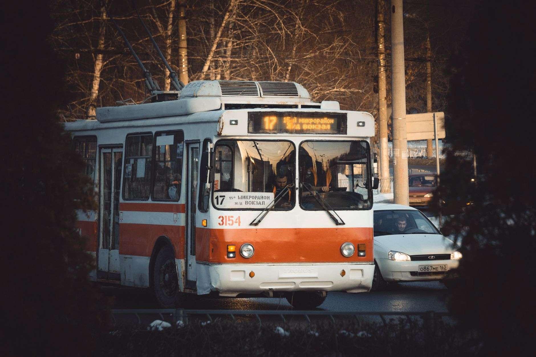 A trolley-style transit vehicle traveling along a downtown city street