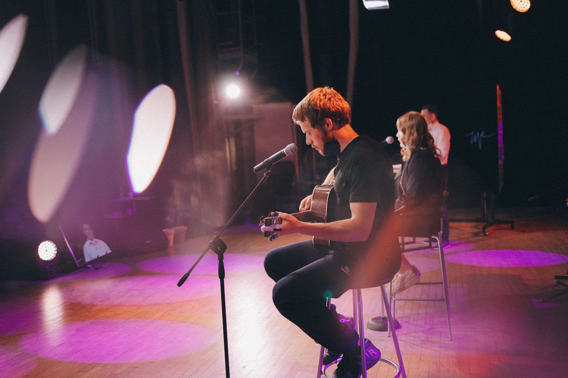 A speaker telling a story at a microphone before an audience