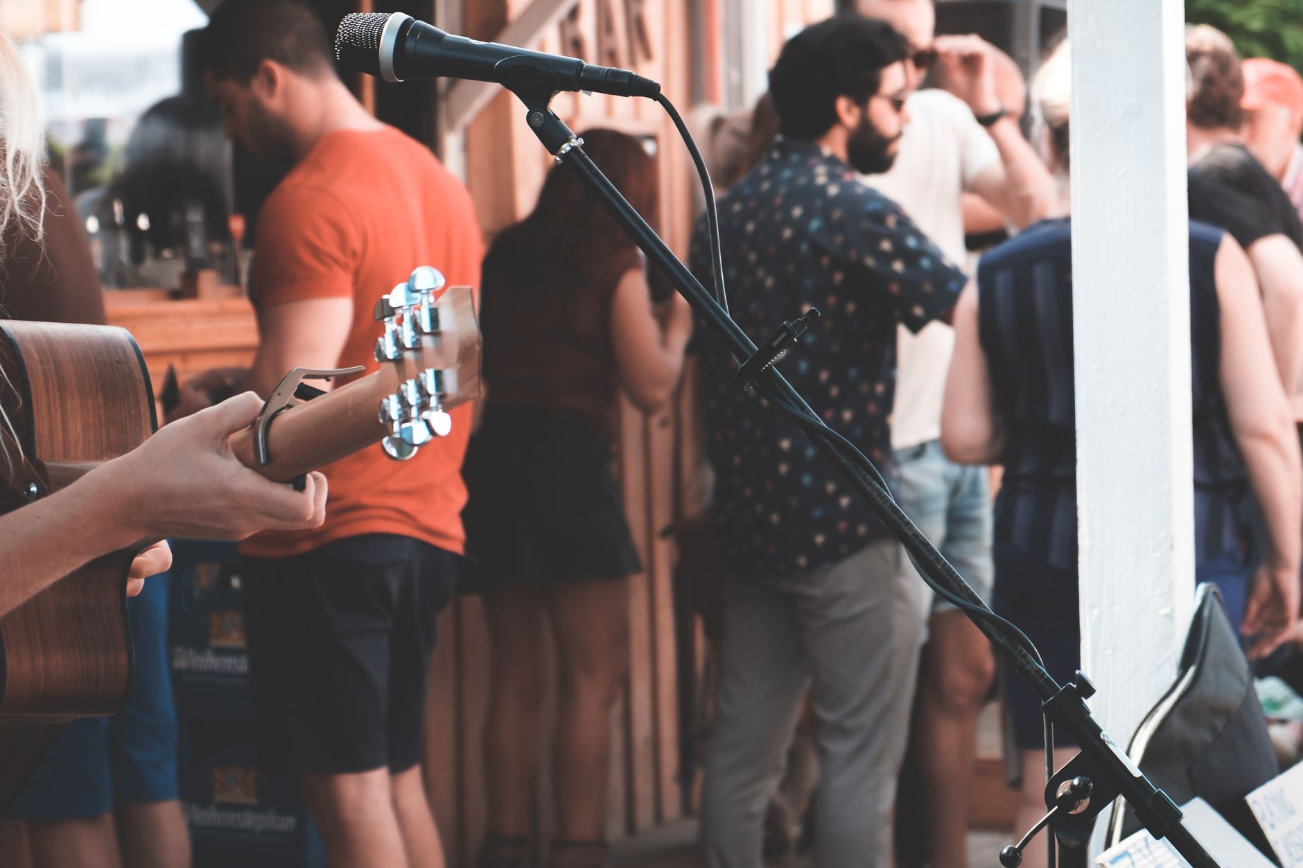 A musician playing acoustic guitar for a small audience in a rustic outdoor setting