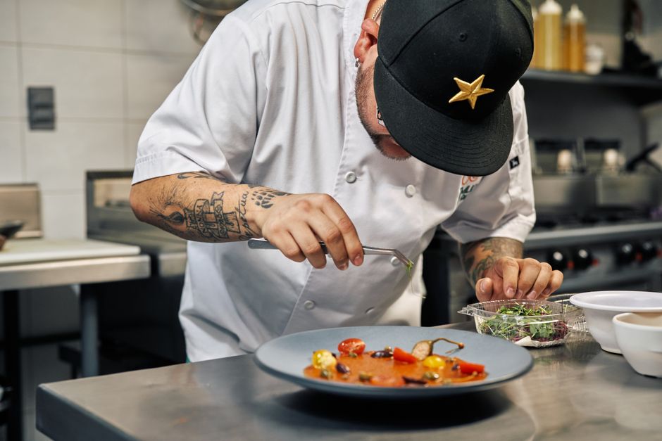 A chef carefully plating a dish in a busy restaurant kitchen