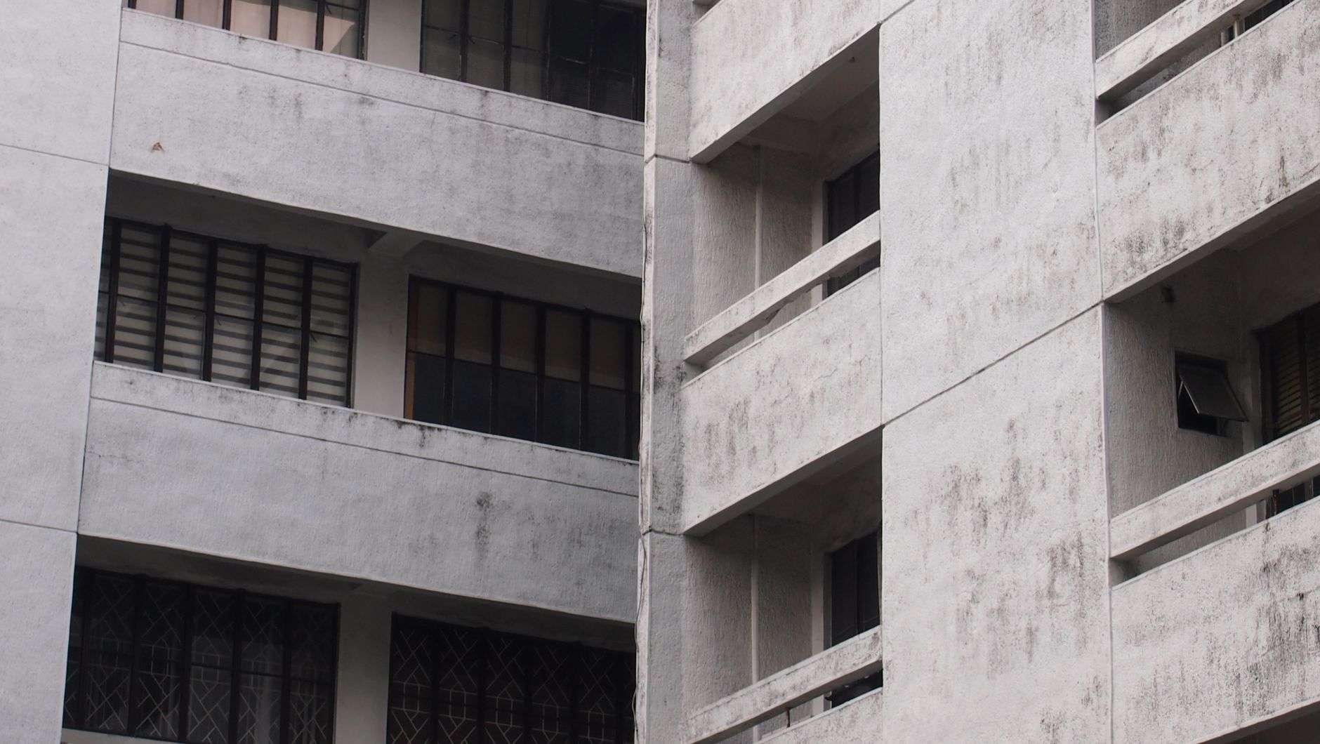 The exterior of a two-story apartment complex with a parking area in front