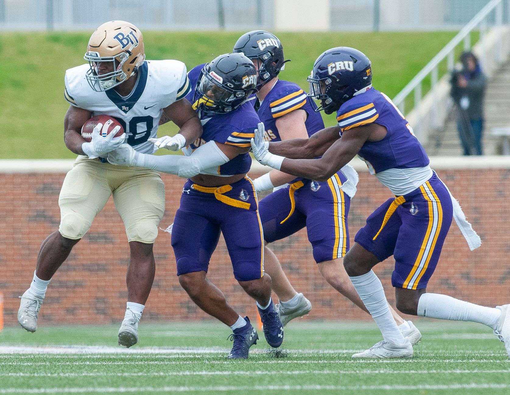 A football player carrying the ball through the line during a game