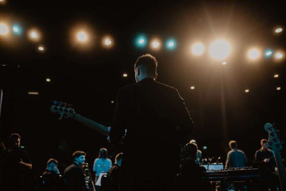 A musician playing a bass guitar on stage at a small club