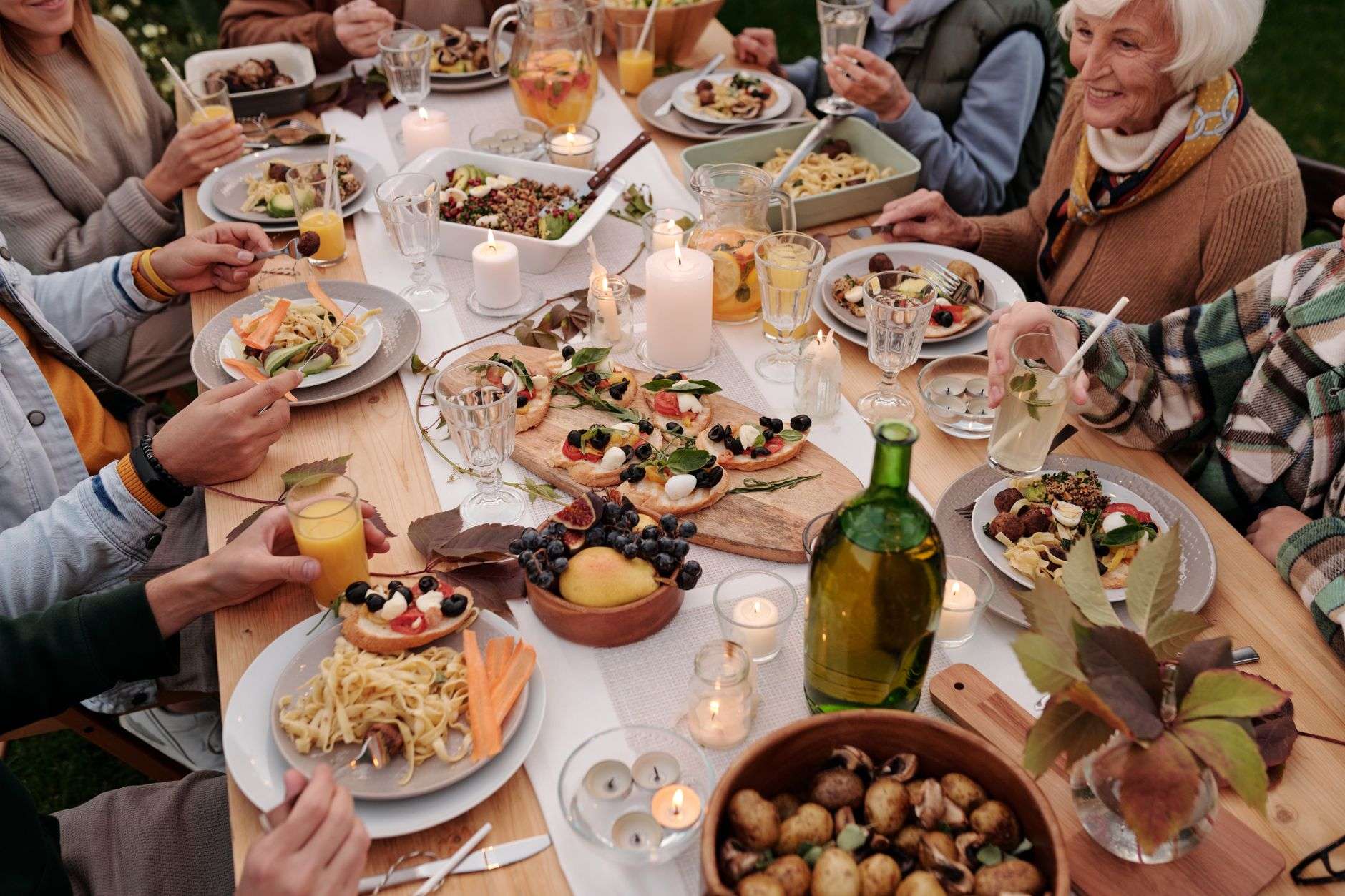 Guests passing dishes around a long communal dinner table
