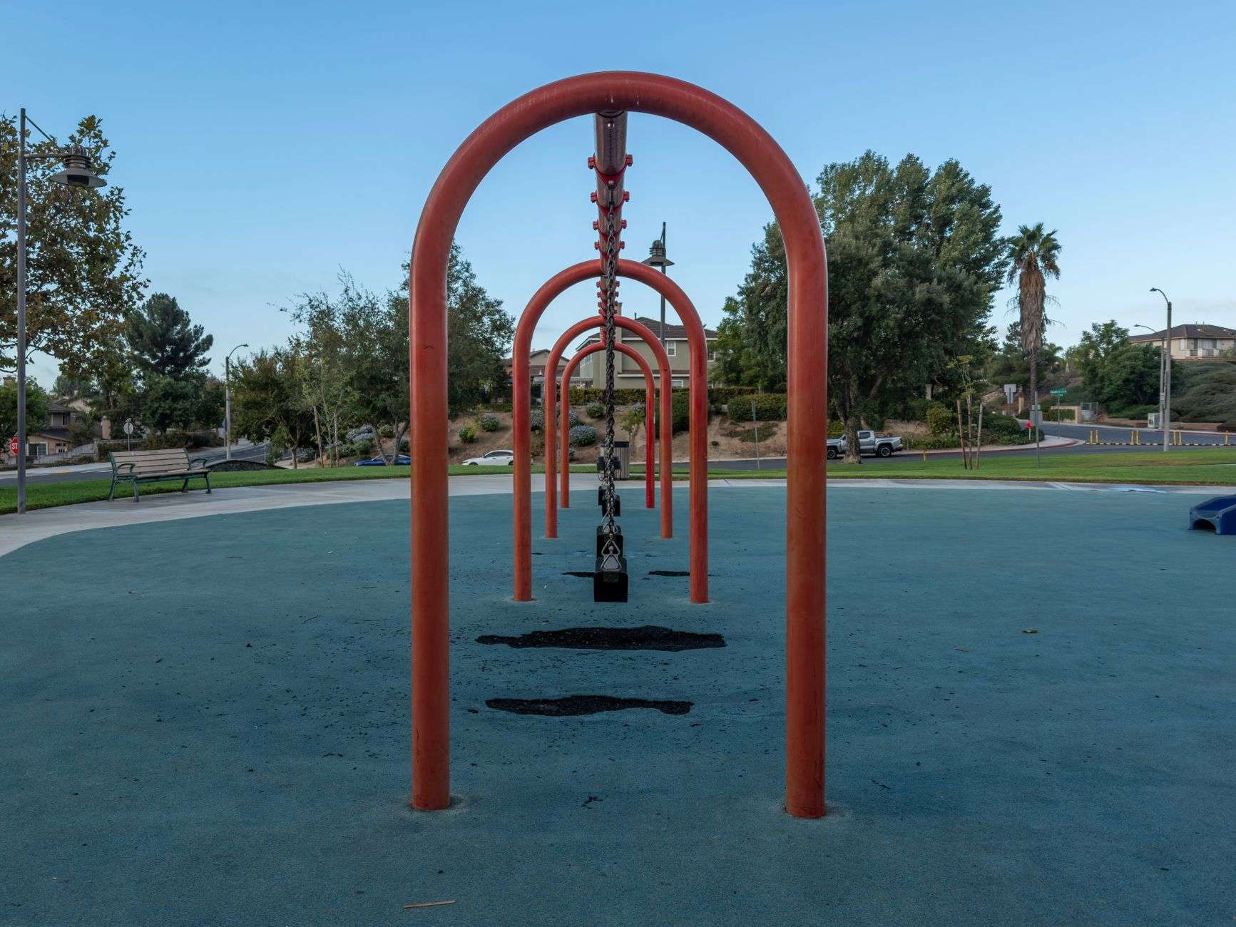 An empty neighborhood park with playground equipment and a ball field
