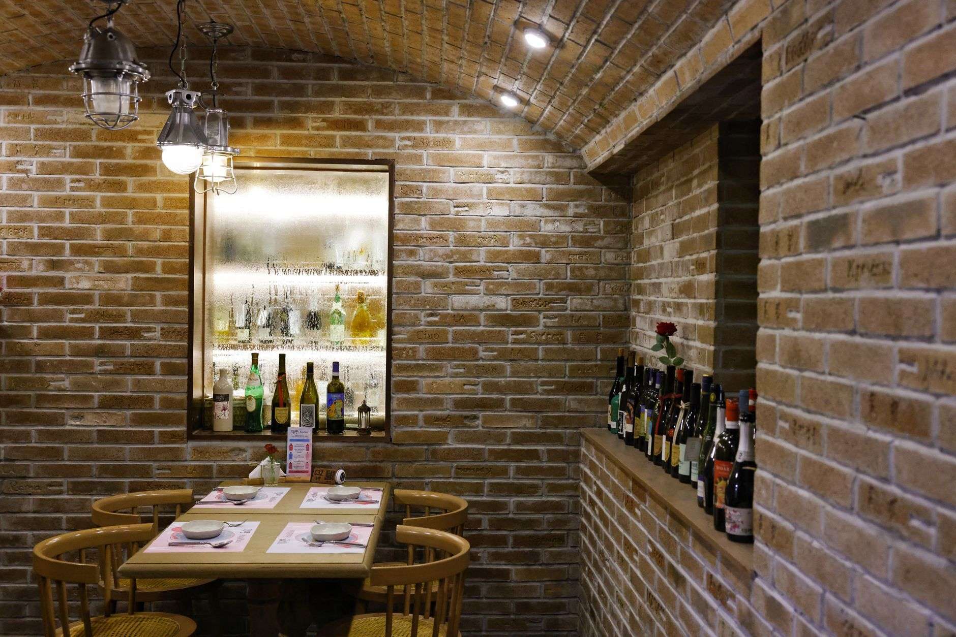 Restaurant interior with exposed brick walls, high ceilings and a long bar