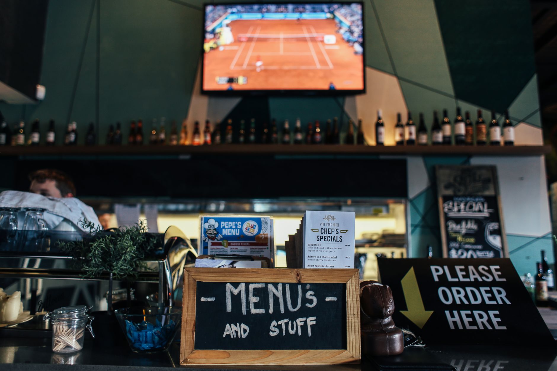 Casual sports bar with televisions above the bar and drinks on the counter