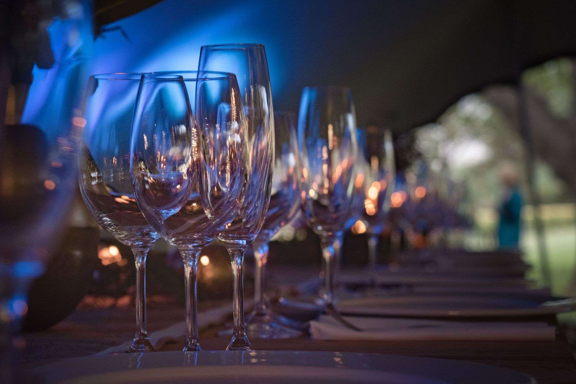 A dinner party table set with fine china, stemware and glasses of wine