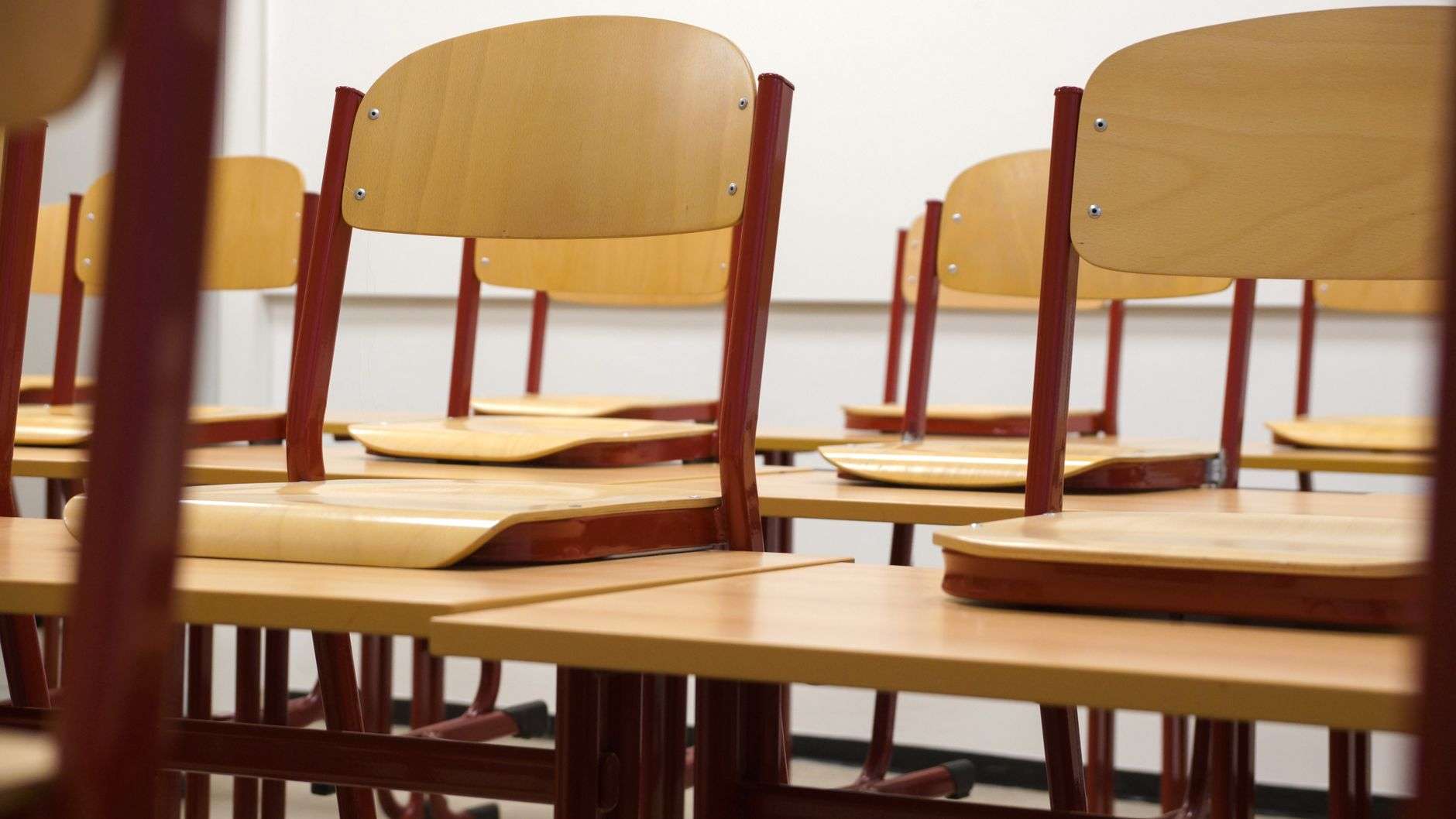 An empty school classroom lined with student desks
