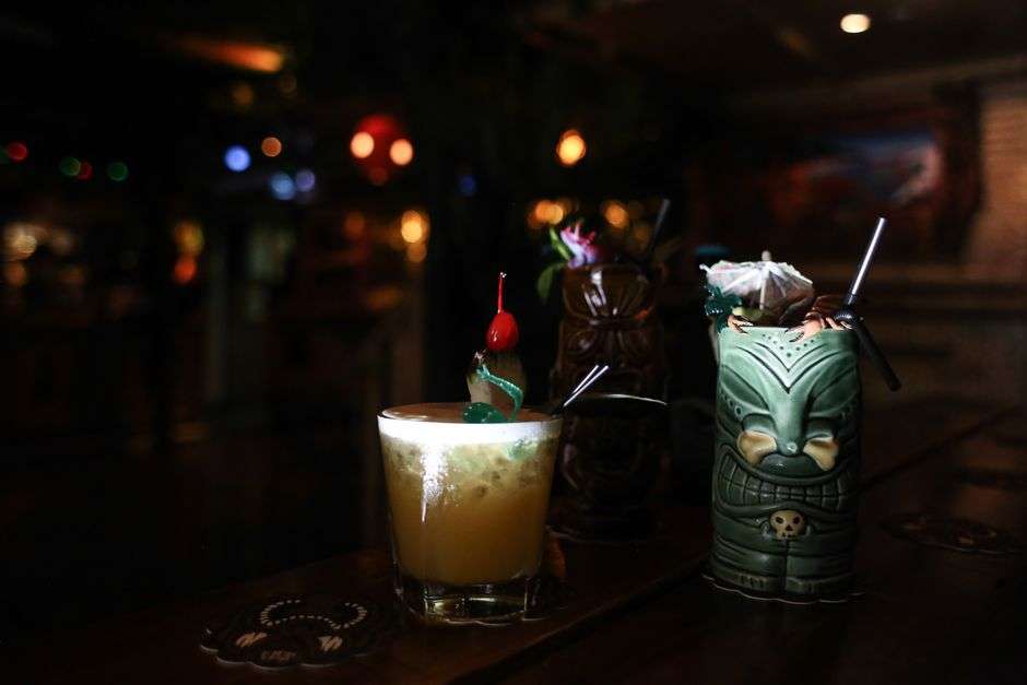 A tiki cocktail with tropical garnish on a bar top