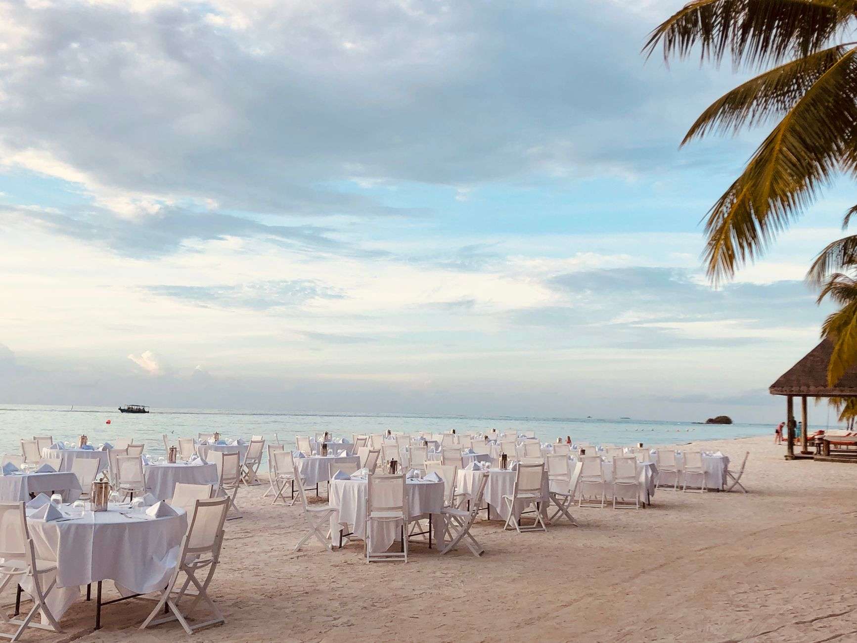 Elegant table settings prepared for an evening gala near the water