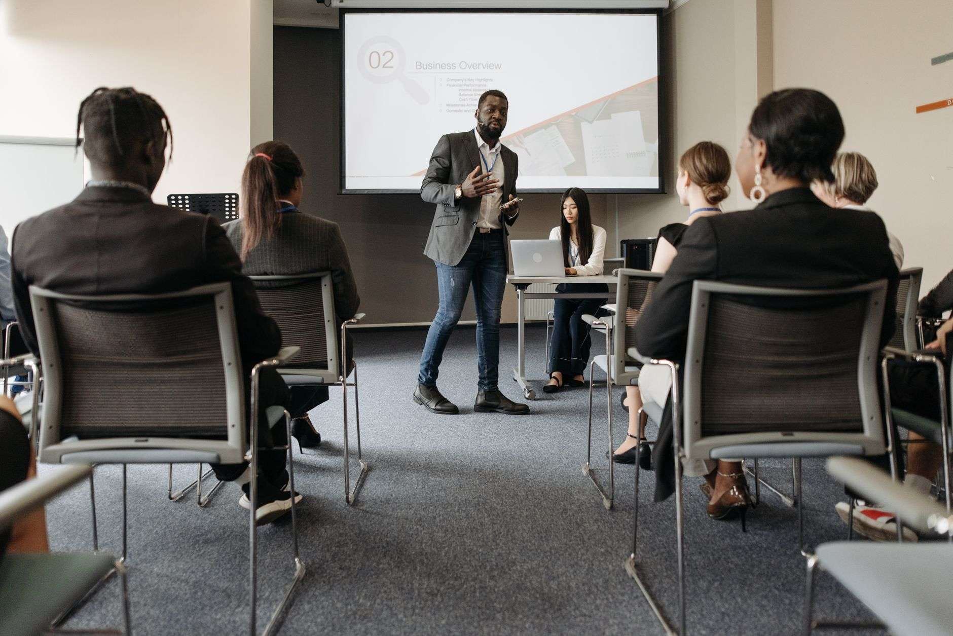 A speaker addressing an audience seated in a meeting room