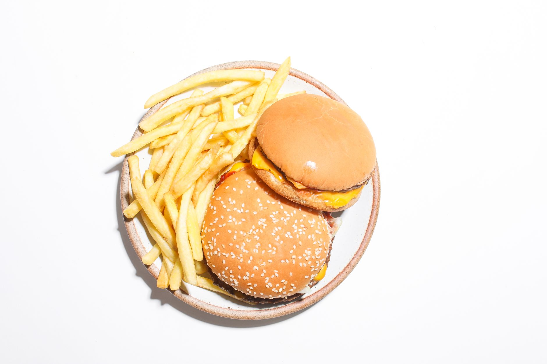 A double cheeseburger and French fries served in a basket