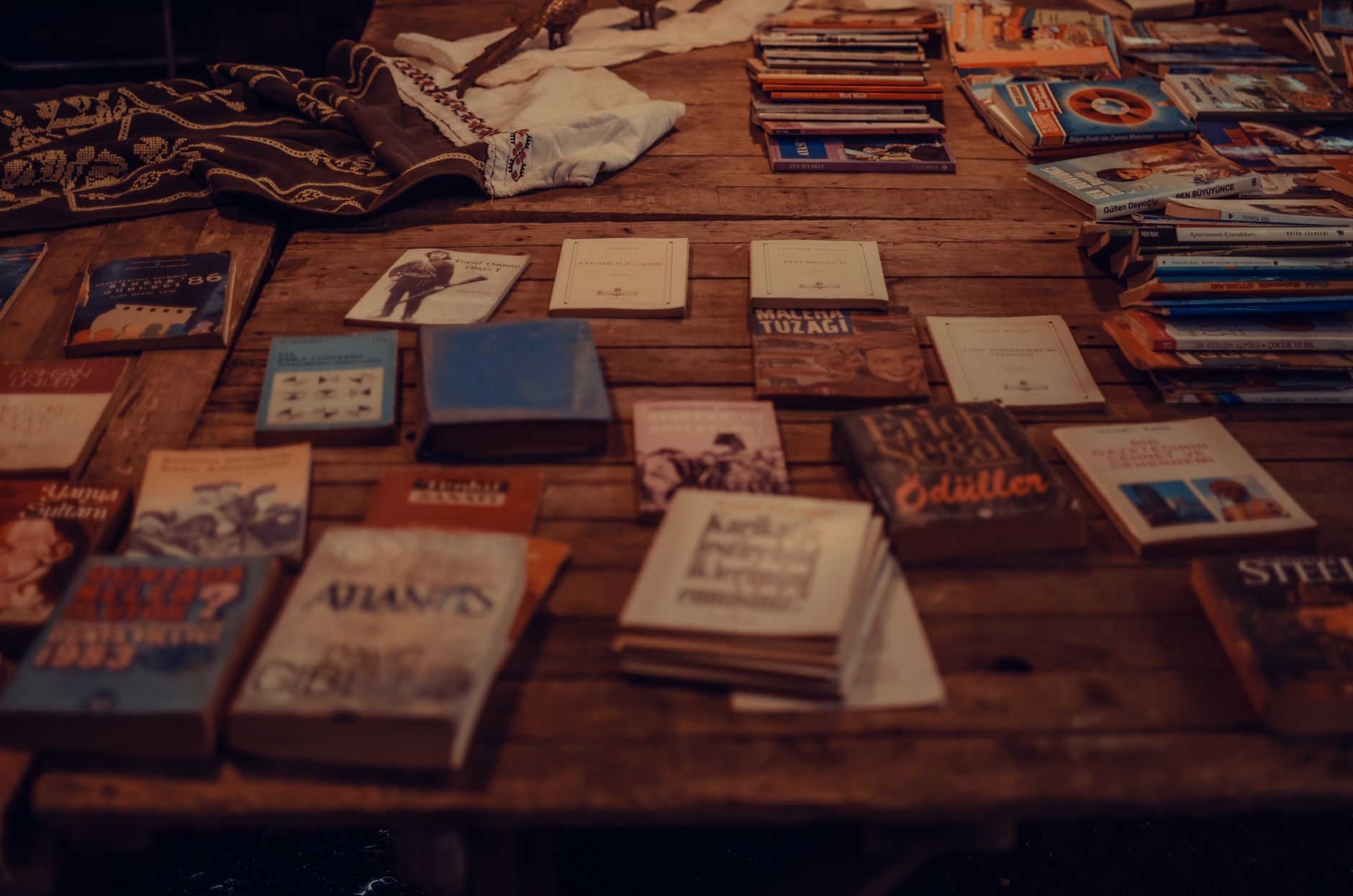 A well-worn hardcover book resting on a rustic wooden table