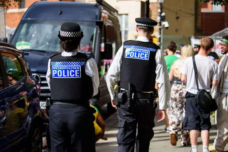 Police officers standing beside a patrol vehicle on a Mobile street
