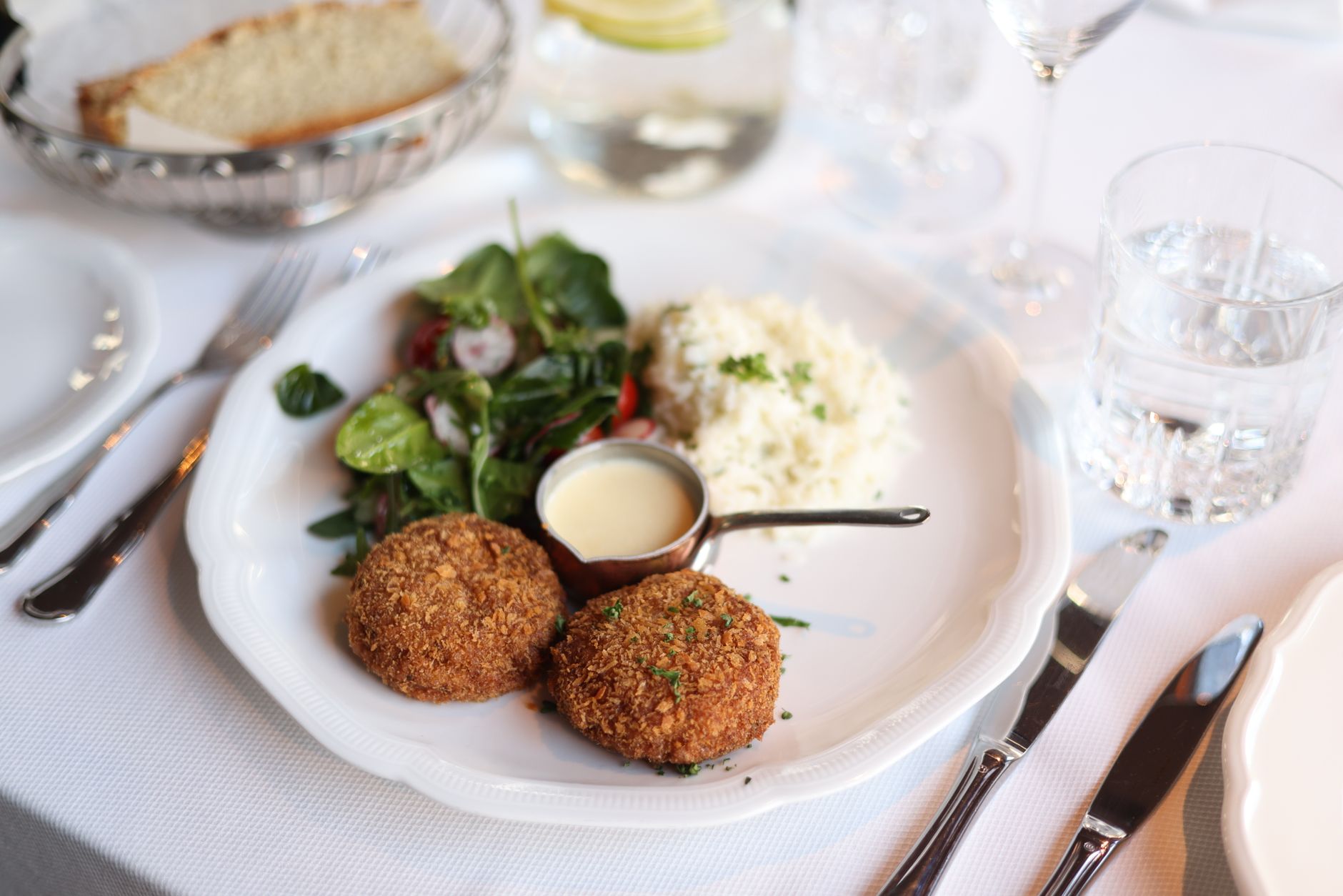 Plate of crab cakes with sauce and sides at a seafood restaurant