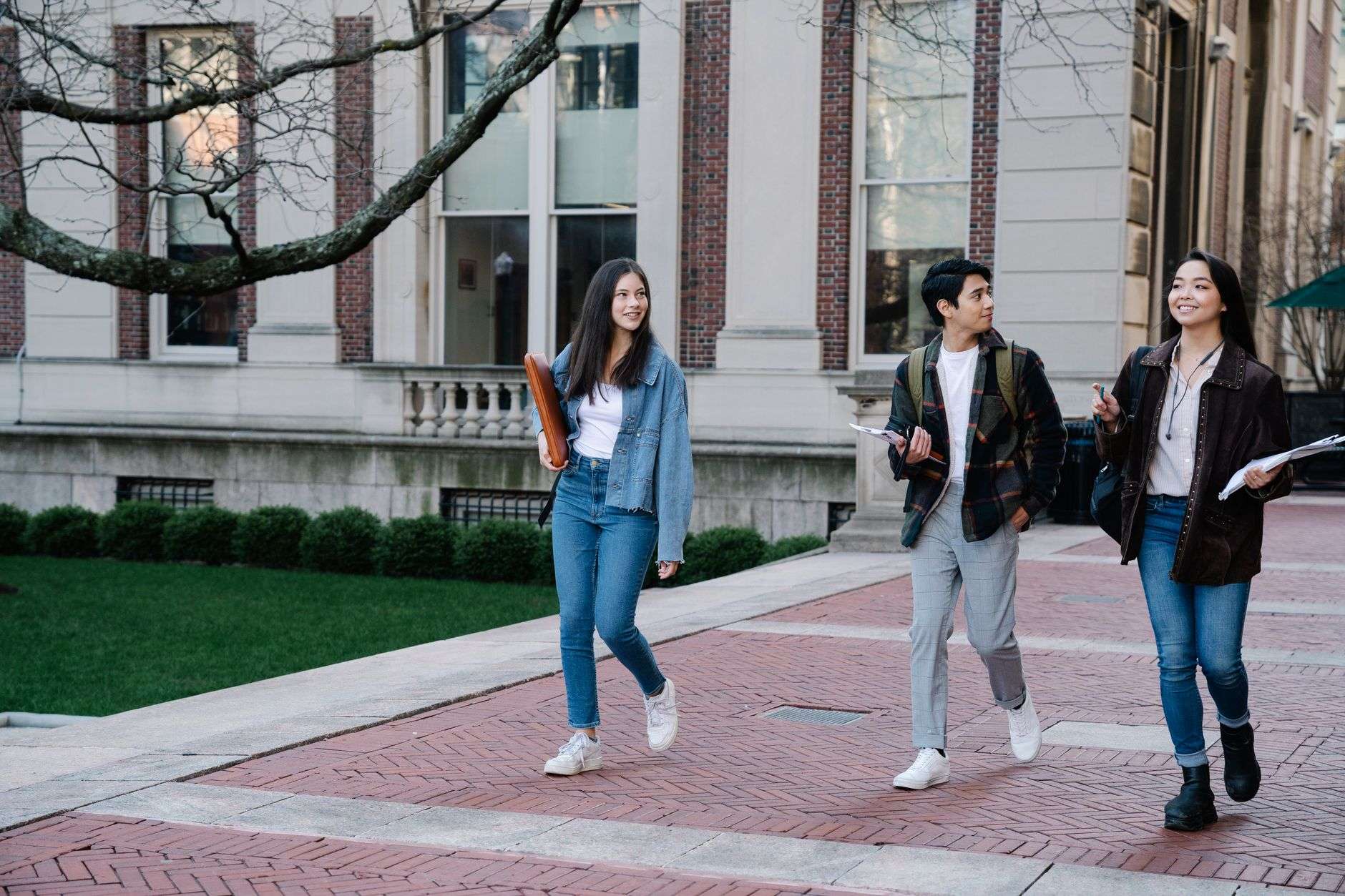 Students walking across a university campus, illustrating record fall enrollment at a public research university