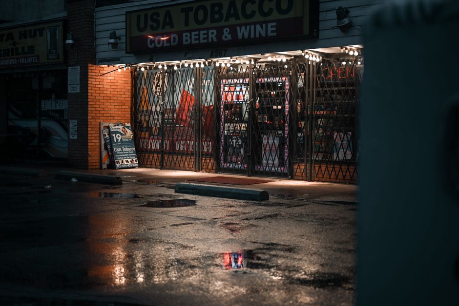 A liquor store storefront with neon signs at night