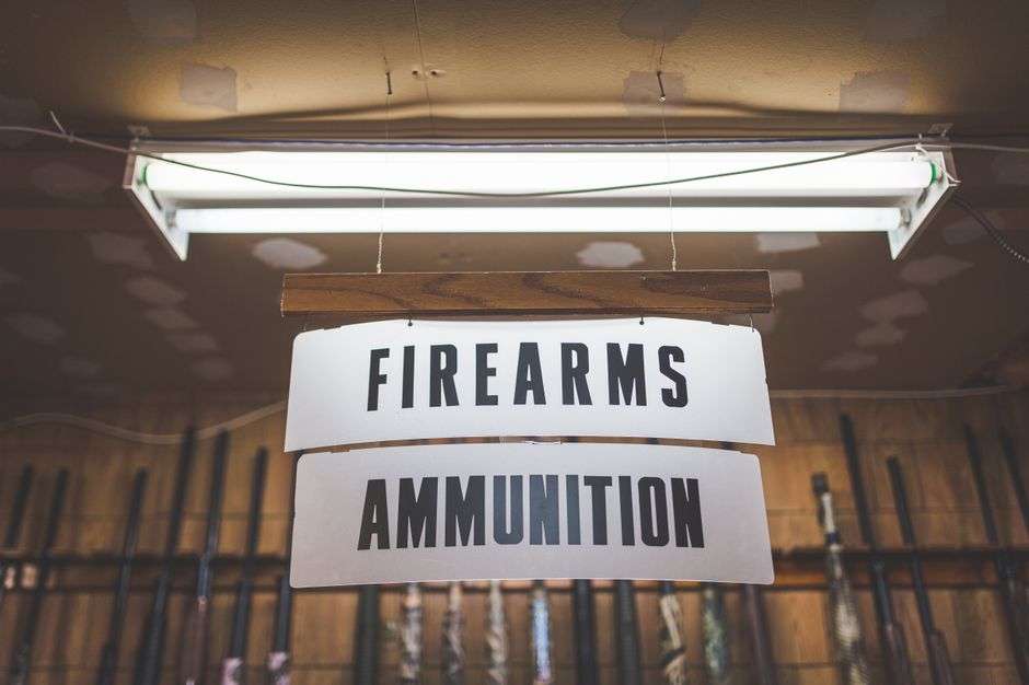 A counter inside a pawn shop with a locked firearm safe behind it