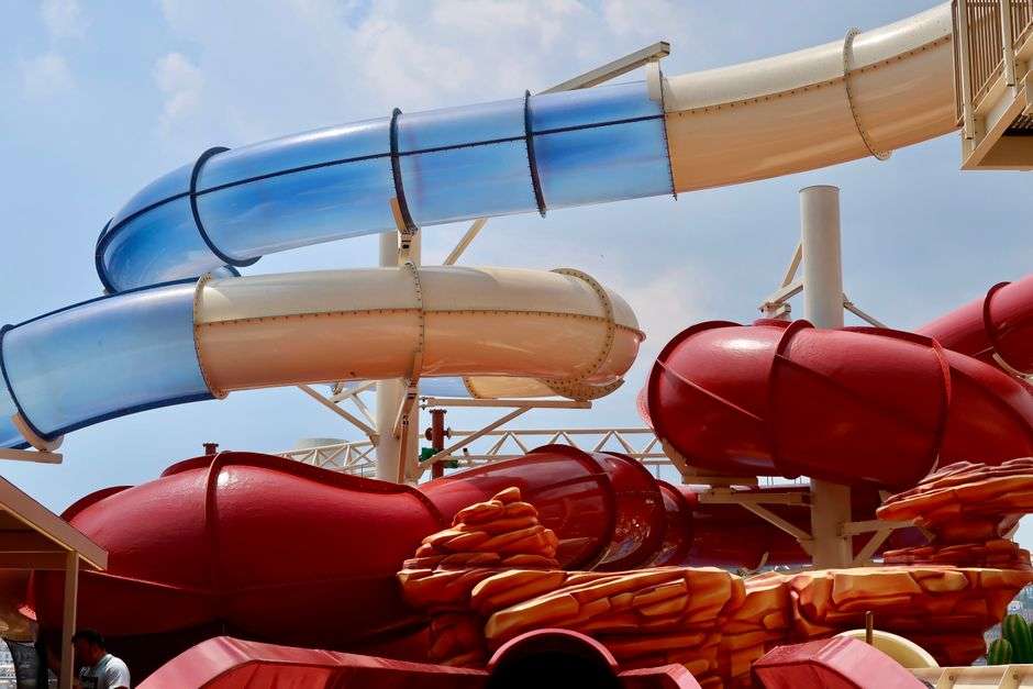 Tall colorful water slides at a water park on a sunny day