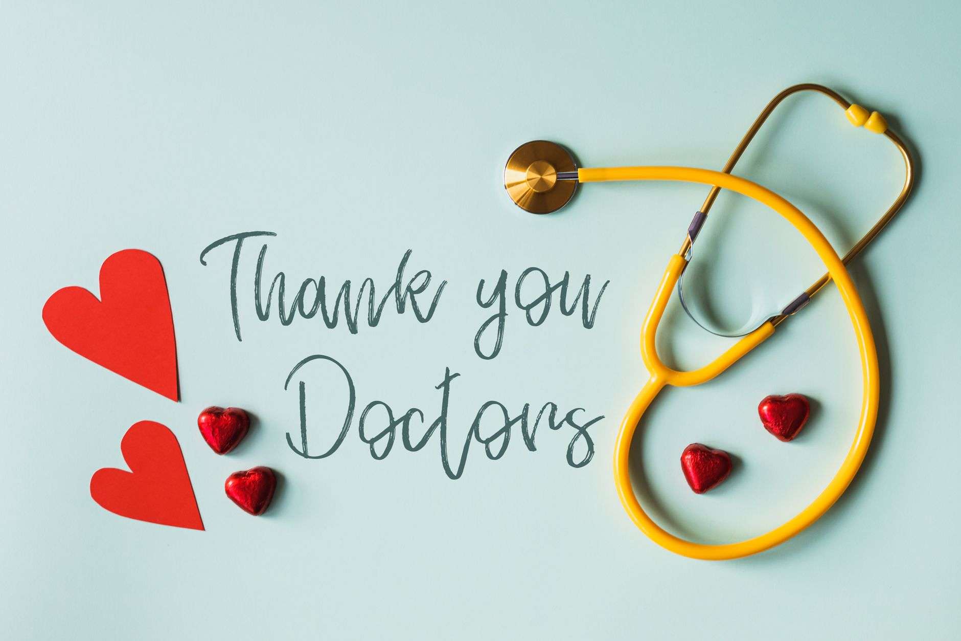 A stethoscope resting beside a red heart shape