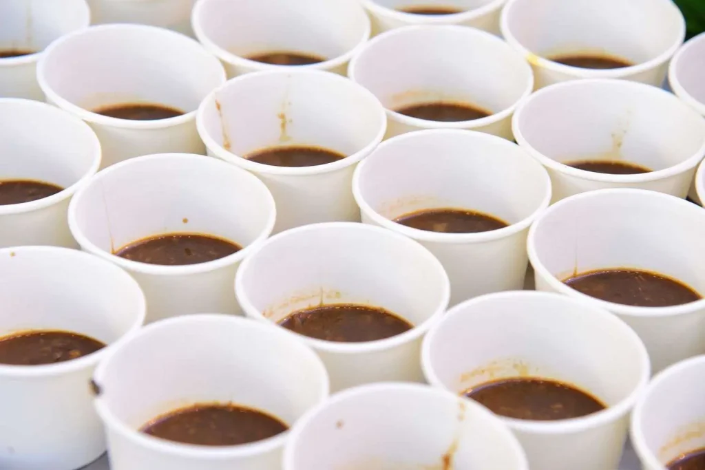 Rows of small sample cups filled with chili at an outdoor cook-off event