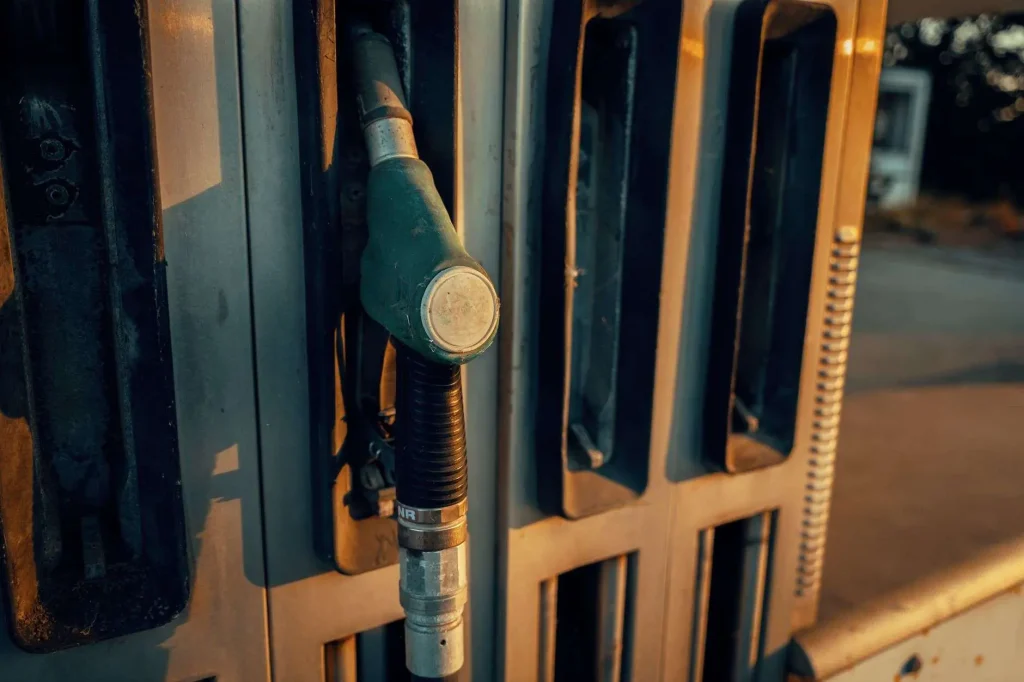 Close-up of a fuel pump nozzle resting in its holster at a gas station
