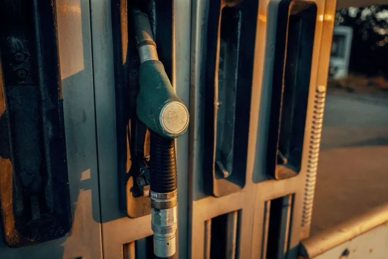 Close-up of a fuel pump nozzle resting in its holster at a gas station