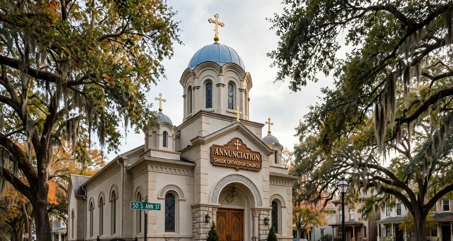 A Greek Orthodox church with a dome and arched windows surrounded by live oaks in a historic Mobile neighborhood