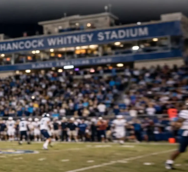 Fans fill the stands of Hancock Whitney Stadium under lights during a night college football game