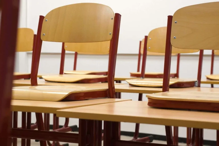 An empty classroom with rows of desks and chairs