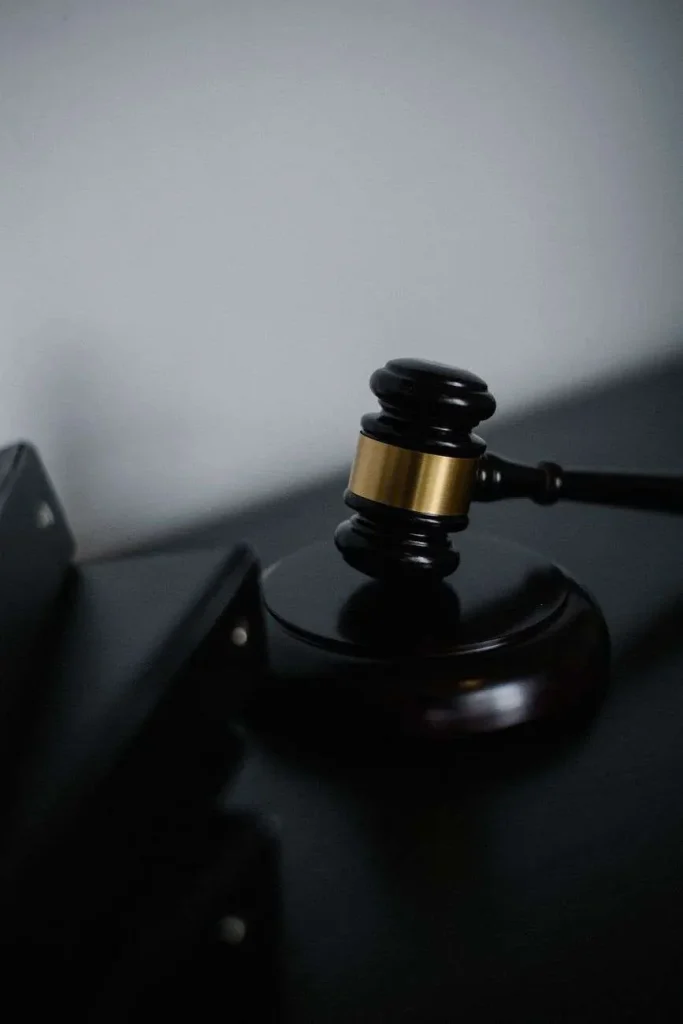 Wooden judges gavel resting on a sound block on a dark surface