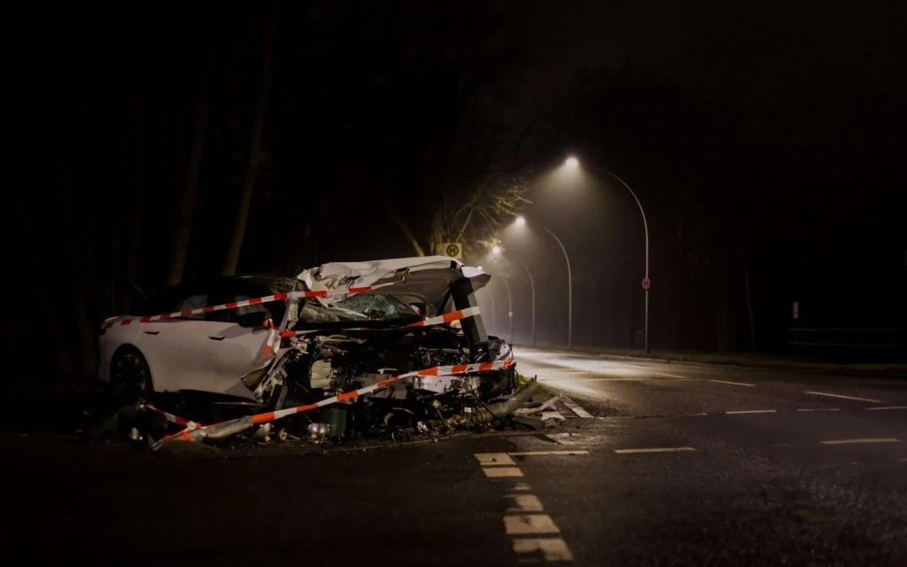 A wrecked car on a dimly lit street at night following a crash
