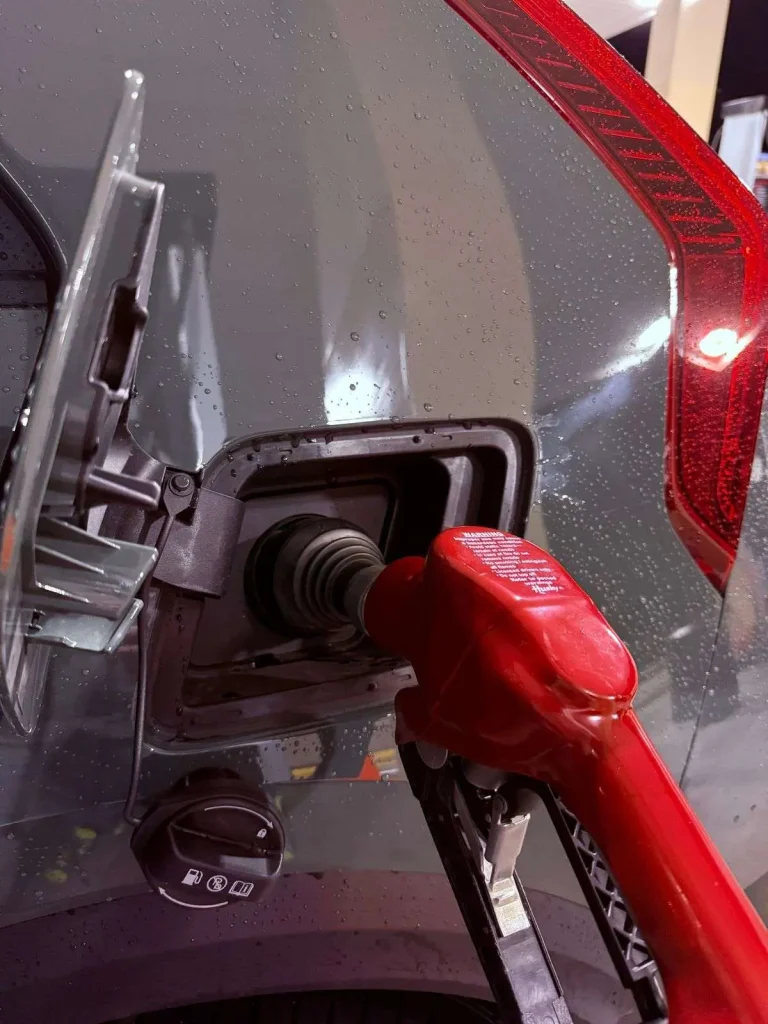 A motorist refueling a car at a gas station pump