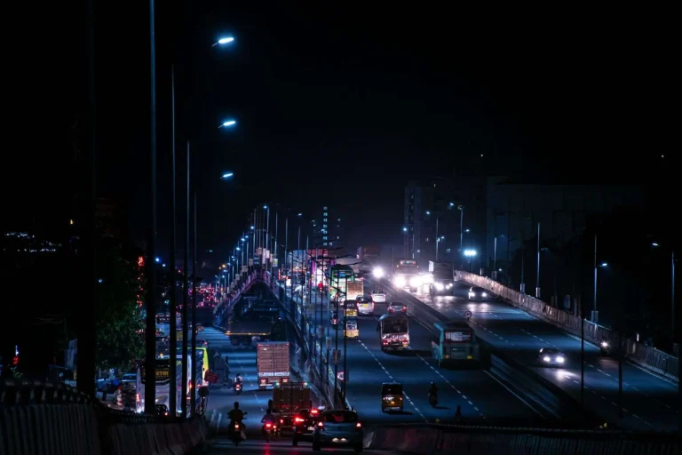 A dark two-lane road at night lit by vehicle headlights