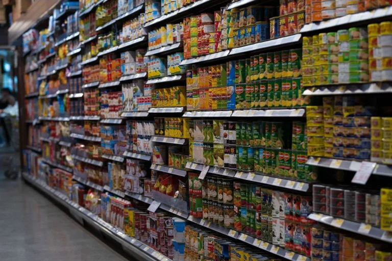 Shelves of canned food products lining a grocery store aisle