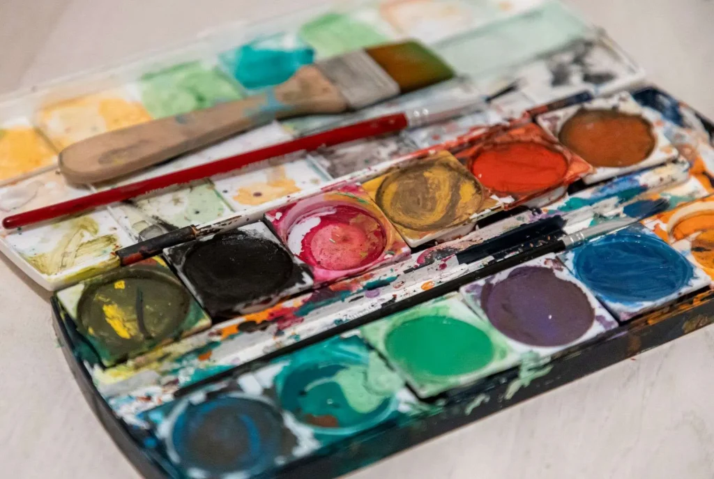 Vibrant watercolor paints and brushes arranged on a table